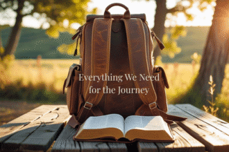 A bible and a backpack sitting on a picnic table that overlooks a sunlit vista